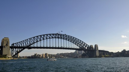 Fototapeta na wymiar small motor boat passing by the Sydney Harbour bridge, Sydney NSW Australia 