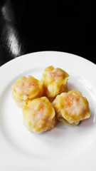 Dimsum: Shumai in white dish put on natural dark wood table.