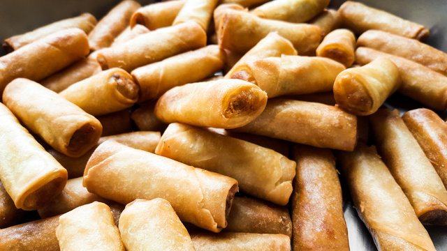 A lot of spring rolls in the large dish at buffet restaurant.