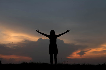 Fototapeta na wymiar silhouette of woman happy alone at sunset