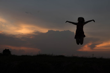 silhouette of woman happy jumping at sunset