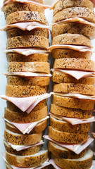 A lot of ham cheese sanwich on white dish.