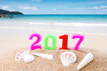 Colorful Candle Number 2 0 1 7 Over Blurred Blue Sea and Sand Beach with Clear Blue Sky ,Image for New Year 2017 Celebration Decorative Concept.