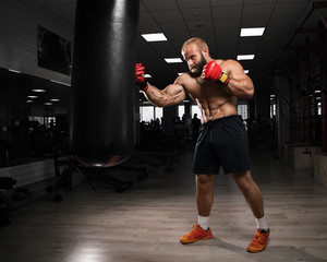 Strong muscular man boxing at the gym.