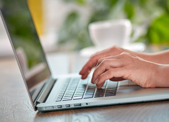 Woman's hands on the keyboard of her laptop computer. Working on