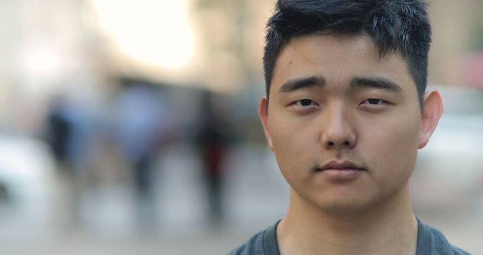 Young Asian man in city face portrait