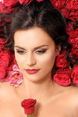 Portrait of fashionable young model lying in red roses