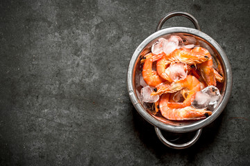 Shrimp with ice in a metal bowl .