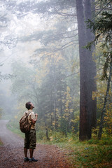 Man walking in a foggy summer forest alone