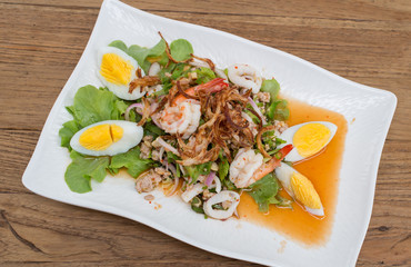 Thai style spicy salad on wood table.