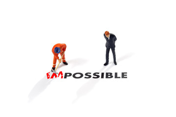 Worker digging with the text impossible, digging the word im so it written possible. success and challenge concept.