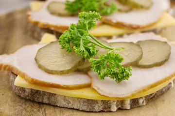 Sandwich with meat and chease on cutting board. Soft focus