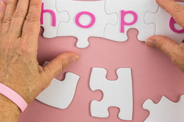 Breast cancer concept. Awareness  pink bracelet and puzzle.