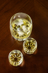 Two small glasses of whiskey and glass of whiskey with ice.