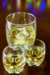 Two small glasses of whiskey and glass of whiskey with ice.