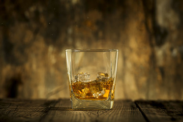 Whiskey glass on wooden table and wooden background