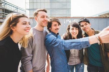 Group of young multiethnic friends taking a selfie with smart phone handhold , having fun - friendship, relaxing concept