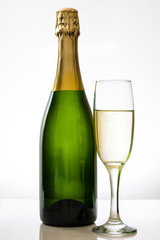 Champagne bottle with a glass cup on white background

