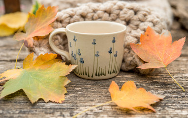Hot coffee and autumn leaves on vintage wood background - seasonal relax concept