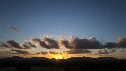 Dramatic sunset sky with orange and blue colored clouds.