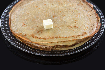 pancakes on a plate on the black glass background