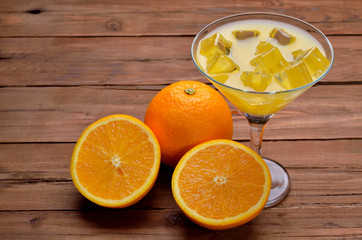 Orange juice with ice in a glass of martini on a wooden table.
