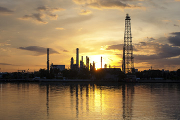 Naklejka premium Zakład petrochemiczny w porze nocnej z odbiciem nad rzeką