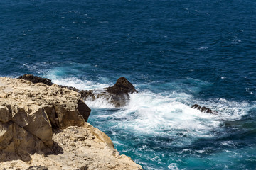 Daylight scene taken in a fischer vilage called Ajuy, located on the western coast of Fuerteventura, Spain. Very intensive blue color of the ocean with white foam hitting some rocks on the coast.
