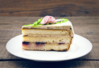Layered cake slice on wooden dark background