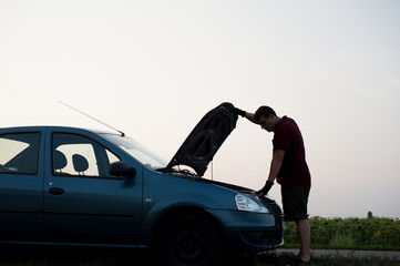Fototapeta na wymiar man repairing his car on the road