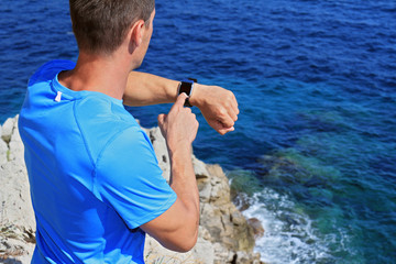 Man runner checking time on smartwatch. Sport, fitness, active lifestyle