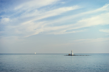 Fototapeta premium Beautiful seascape. Calm sea and white lighthouse on the island.