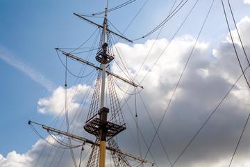 Ship's mast sailboat on a background of clouds in the sky. The romance of travel and far wandering....