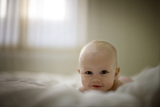 Portrait of a young baby on a bed.
