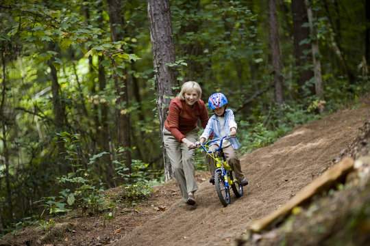 Grandmother teaching her grandson to ride a bike