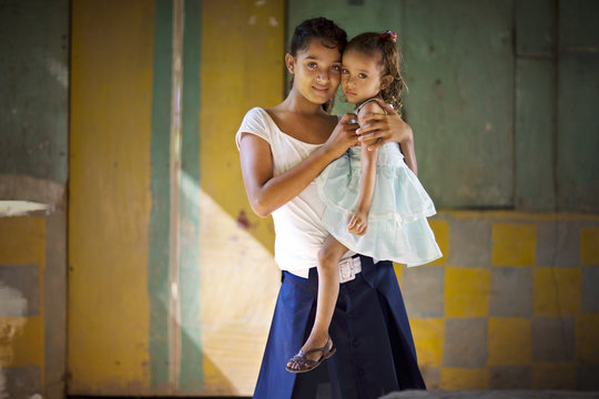 View of a teenage girl carrying her sister.