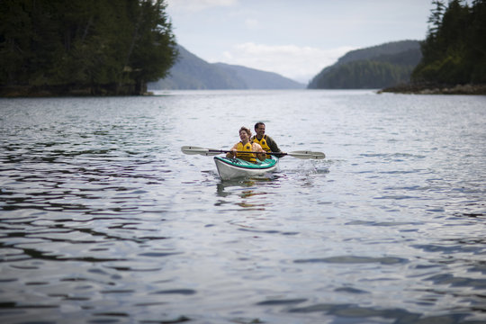 Happy mid-adult couple sitting in a kayak on a lake.