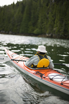 Man sitting in a kayak on a lake.