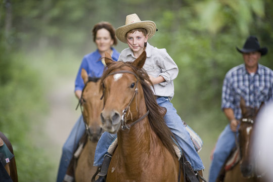 Family on horse trek through forest