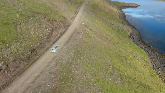 4x4 driving on a gravel road, on a steep hillside in western Iceland.
