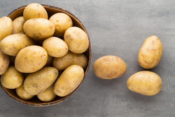 New potato on the bowl, gray background.
