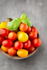 Tomatoes on the gray background. Colorful tomatoes, red tomatoes