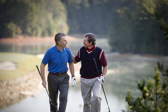 Two mature men enjoying a game together on a golf course.
