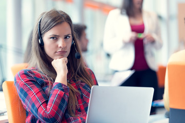 Close up plan of a smiling businesswoman in a call centre