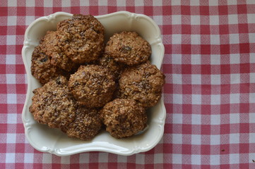 Homemade oatmeal cookies with linseed and nutella on napkin in red plaid
