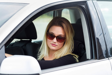 Obraz na płótnie Canvas young blonde woman driver in her car