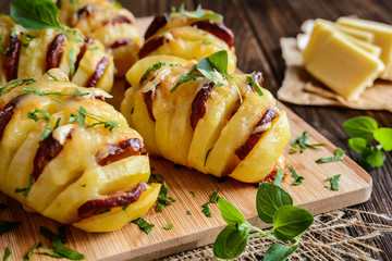 Baked potatoes stuffed with smoked sausage slices, cheese, garlic and herbs
