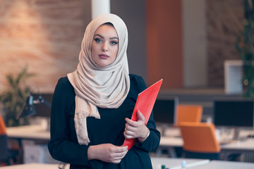 Arabian business woman holding a folder in modern startup office