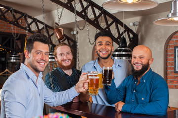 Man Group In Bar Clink Glasses Toasting, Drinking Beer Hold Mugs, Mix Race Cheerful Friends Wear Shirts