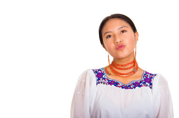 Beautiful young woman standing wearing traditional andean blouse and red necklace, facing camera...